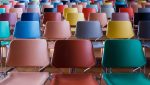 Rows of different coloured chairs, manufactured by Polymer Link, are arranged from the bottom to the top of the staircase