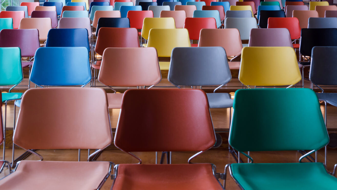 Rows of different coloured chairs, manufactured by Polymer Link, are arranged from the bottom to the top of the staircase