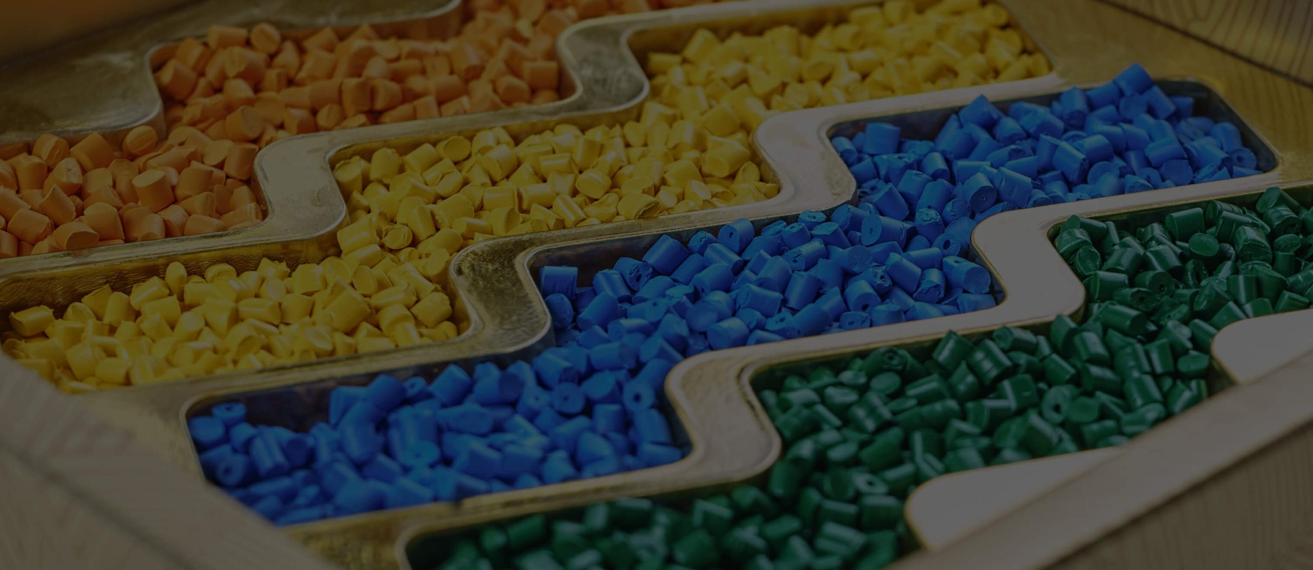 Orange, yellow, blue and green coloured masterbatches manufactured by Polymer Link are neatly stored in a container