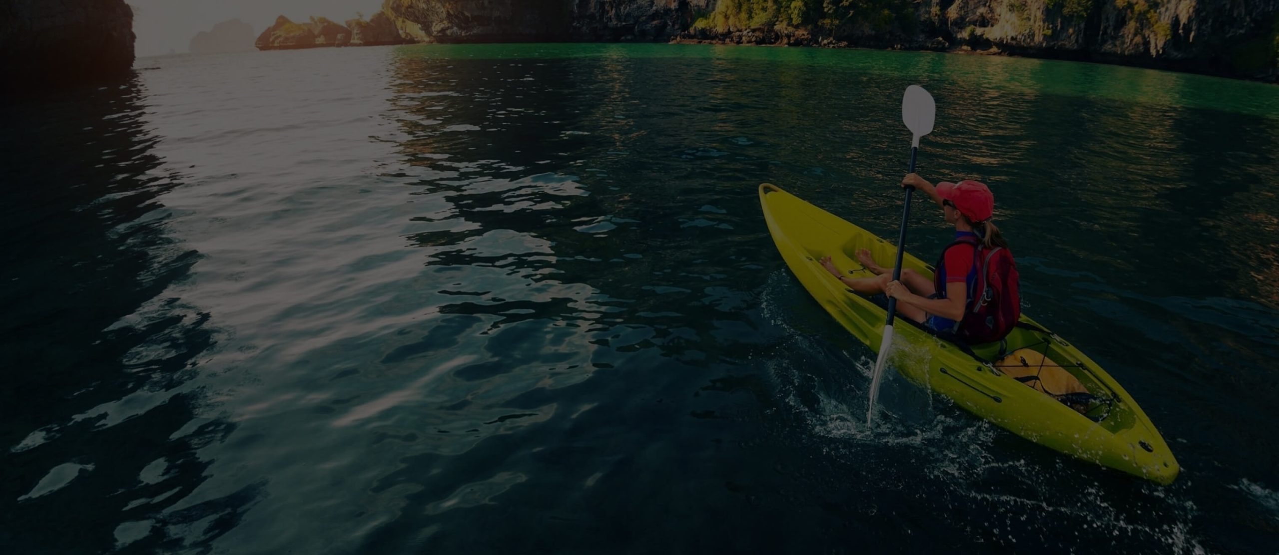 A woman is kayaking using a kayak and a double-blade paddle manufactured by Polymer Link