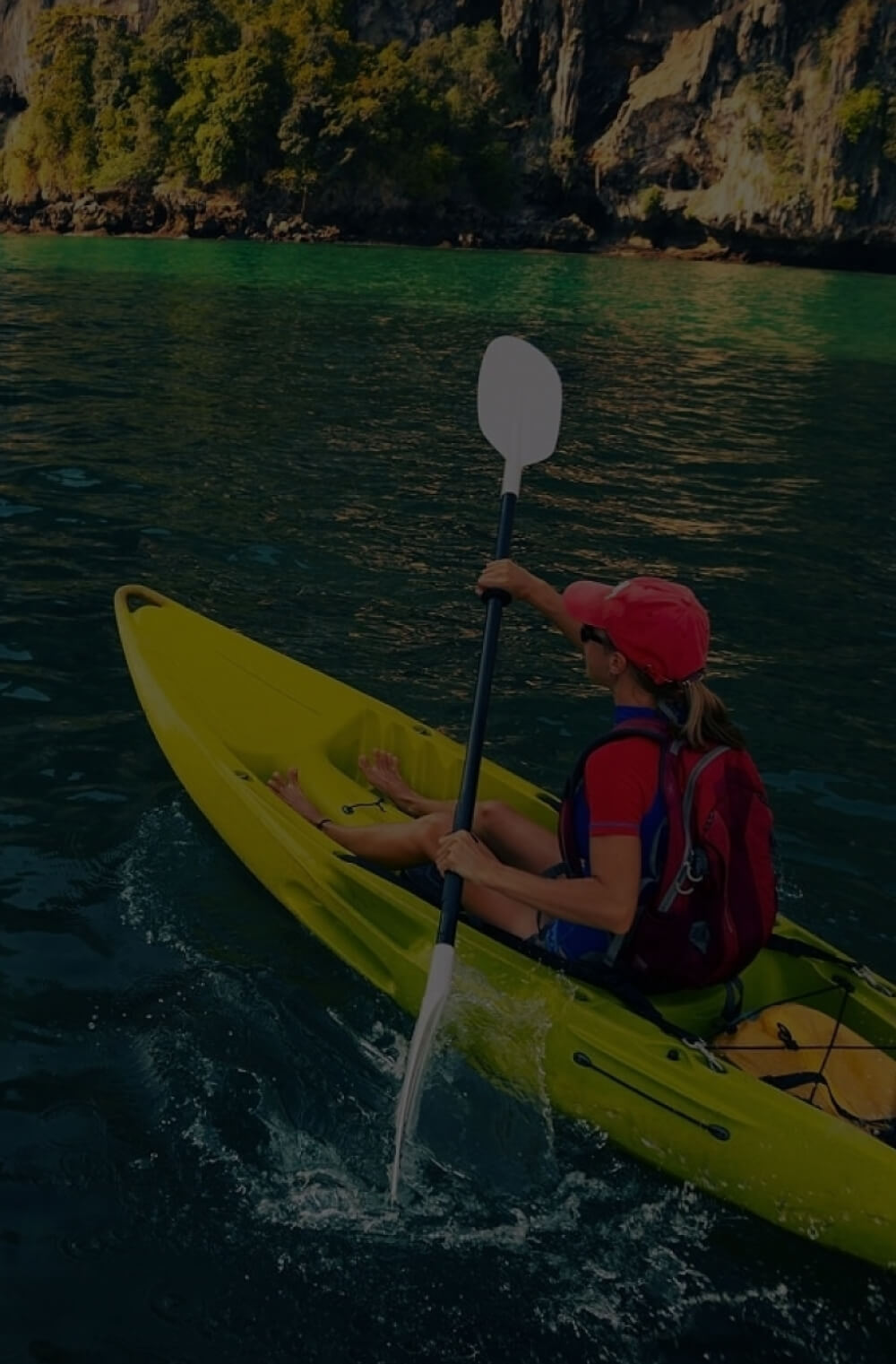 A woman is kayaking using a kayak and a double-blade paddle manufactured by Polymer Link