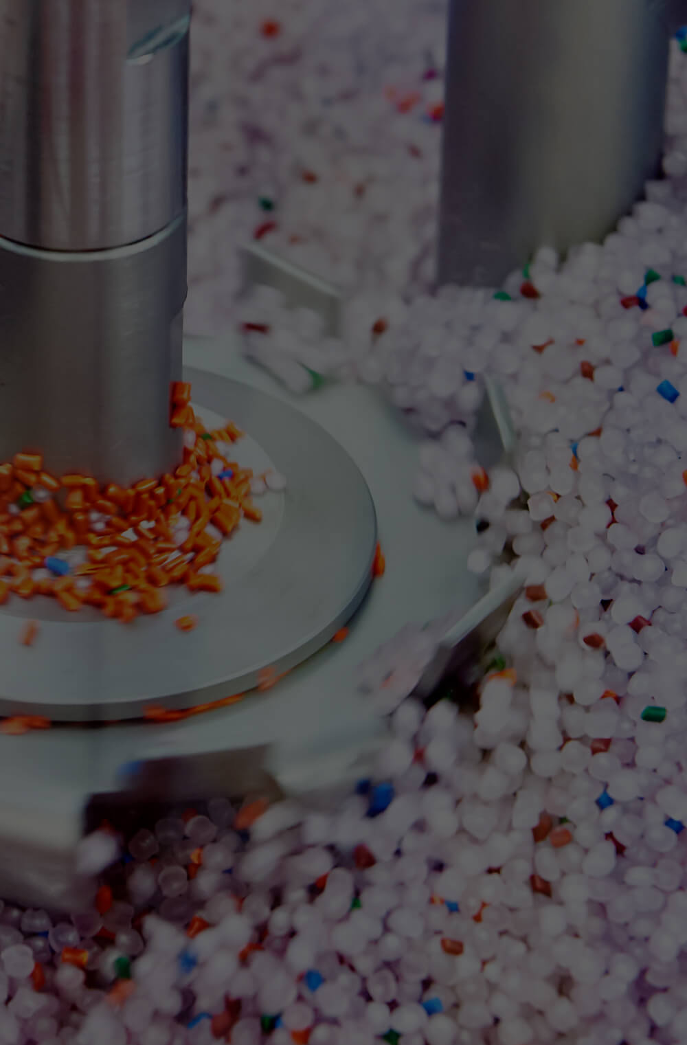 Orange, blue, red, and green coloured masterbatches, along with white coloured masterbatches manufactured by Polymer Link, are being mixed in a rotomoulding machine