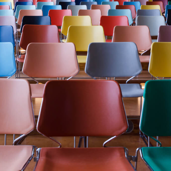 Rows of different colored chairs, manufactured by Polymer Link, are arranged from the bottom to the top of the staircase