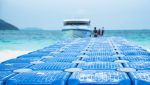 Blue floating docks are made using Masterbatch Solutions by Polymer Link, located near the sea with a ship docked