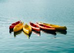 Floating effortlessly on the water, a fleet of red and yellow kayaks awaits adventure, a testament to Polymer Link's commitment to quality and the great outdoors